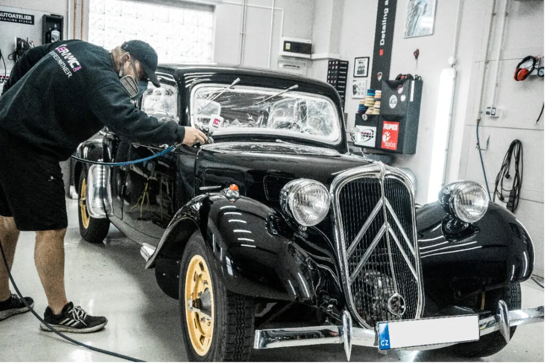 Technik AutoAteliéru pracuje na renovaci černého historického Citroënu z roku 1937